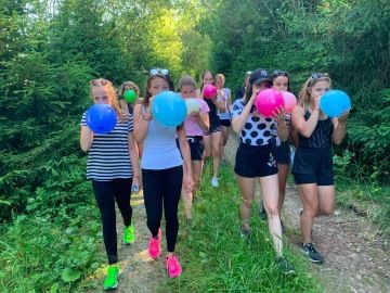 Děti na výletě nafukují balónky