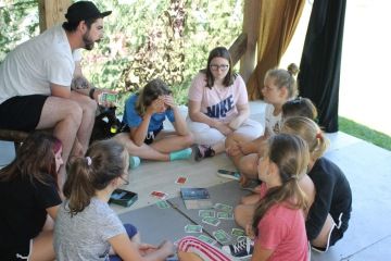 Skupinka děti s lektorem vymýšlí řešení úkolu